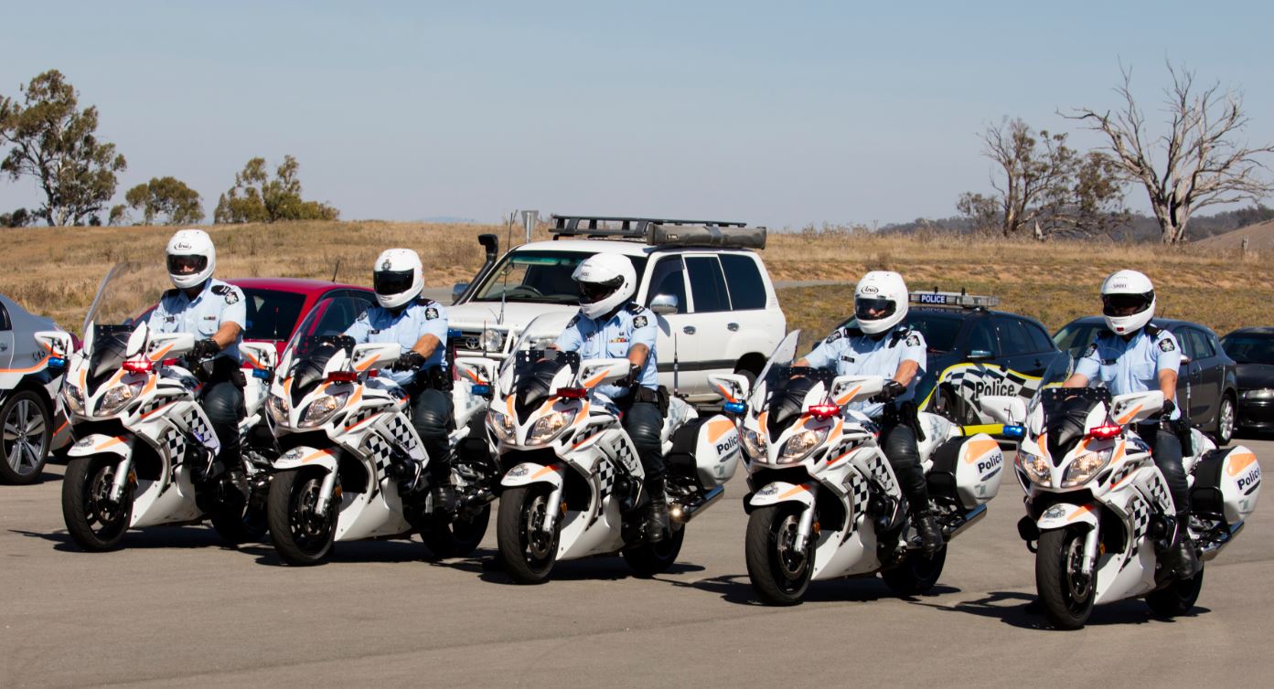Graduates from the Advanced Motorcycle Program line up in formation on their motorcycles.