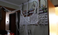An overloaded power supply with multiple extension cords plugged into multiple sockets