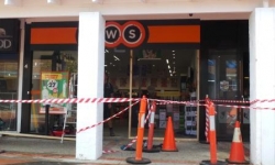 Image of damaged Charnwood BWS Liquor shop front which has been taped off. 