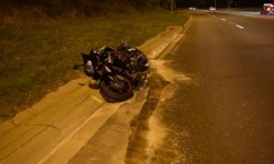 Motorbike crashed on the kerb of the road with debris