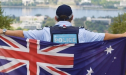 A police officer holding the Australian flag