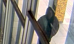 Image of a man in a black hoodie on CCTV footage